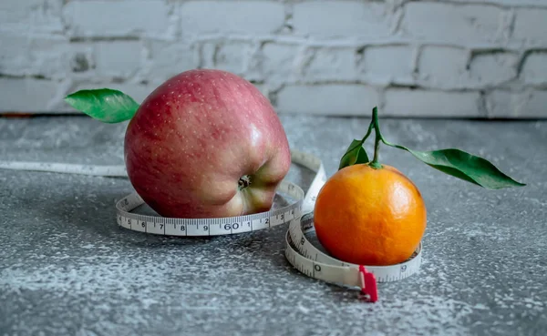 Red apple and orange for weight loss while dieting, centimeter measuring tape
