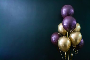 Koyu arkaplanda altın ve mor toplar var. Tatil konsepti, kartpostal.