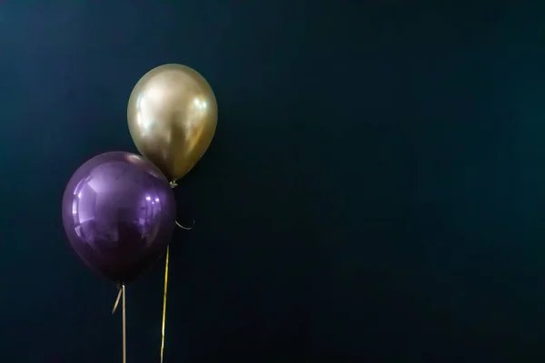 Gouden ballon en violette ballon op een donkere achtergrond. Vakantie Concept, Postkaart — Stockfoto