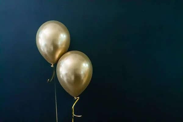 Twee gouden ballonnen op een donkere achtergrond. Vakantie Concept, Postkaart — Stockfoto