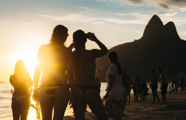 Gün batımını Ipanema Plajı, Rio de Janeiro, Brezilya fotoğrafını iki kadın silüeti