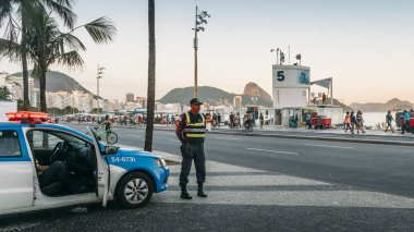Local Brazilian policemen watch over locals and tourists in Copacabana clipart