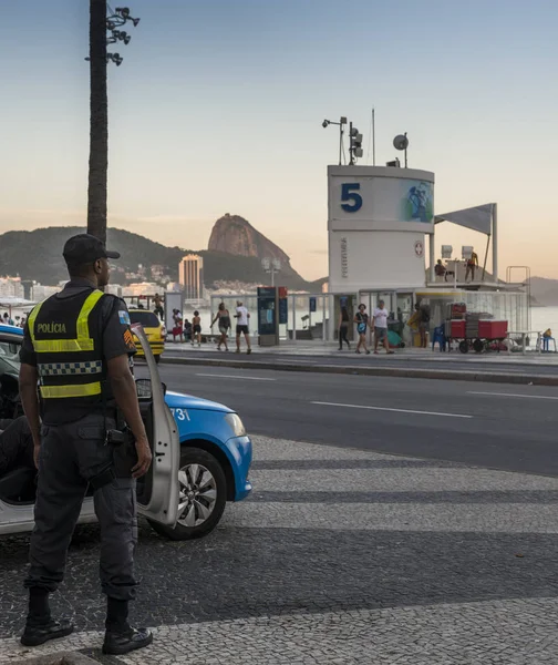 Yerli halk ve turistler Copacabana üzerinden yerel Brezilya polis izle
