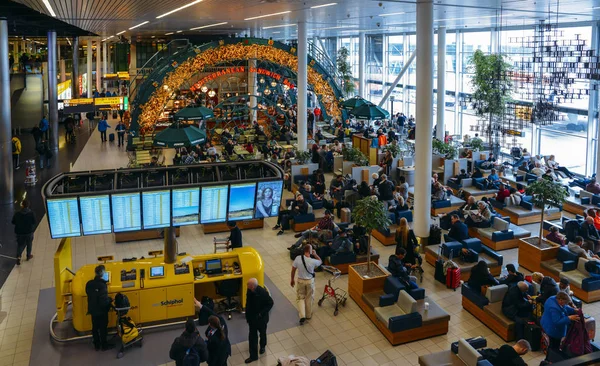 Busy departure lounge at Amsterdams Schiphol Airport which serv — Stock Photo, Image
