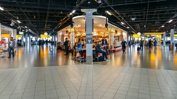 Busy departure lounge at Amsterdam's Schiphol Airport which serv — Stock Photo, Image
