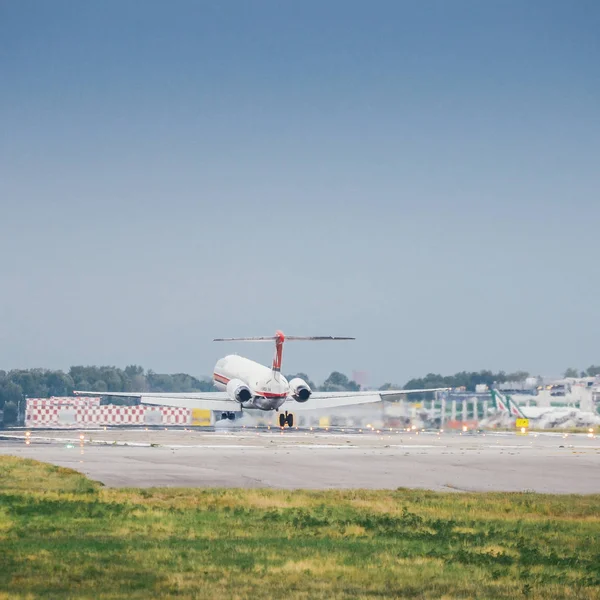 A meridiana airliner commercial airplane lands at Milan's Linate airport. Linate is a main hub for Alitalia servicing many short and medium range — Stock Photo, Image