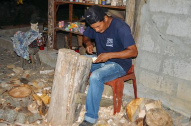 Local Quechua Ecuadorian indigenous man chipping away at a piece clipart