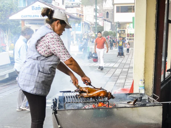 Mujer ecuatoriana preparando un manjar ecuatoriano llamado lechón, barbacoa un pequeño tipo de cerdo a la parrilla — Foto de Stock