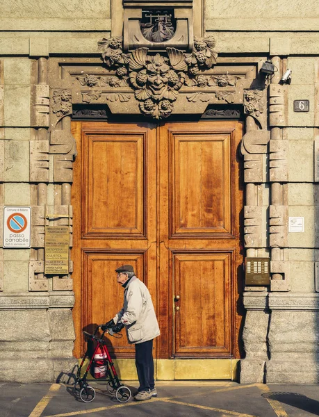 Homem mais velho na frente da fachada gótica e enorme porta de madeira em Milão, Lombardia, Itália — Fotografia de Stock