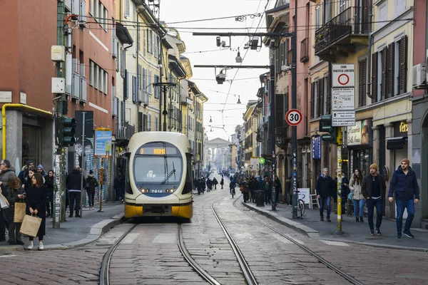 Yellow Milanese tram at busy street in the Navigli district with Porta Ticinese in the background — Stock Photo, Image