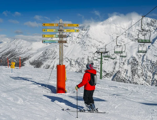 Skiër kijken Wegwijzer in het skigebied van La Thuile, wijst naar verschillende pistes met inbegrip van naar de Franse badplaats La Rosiere — Stockfoto