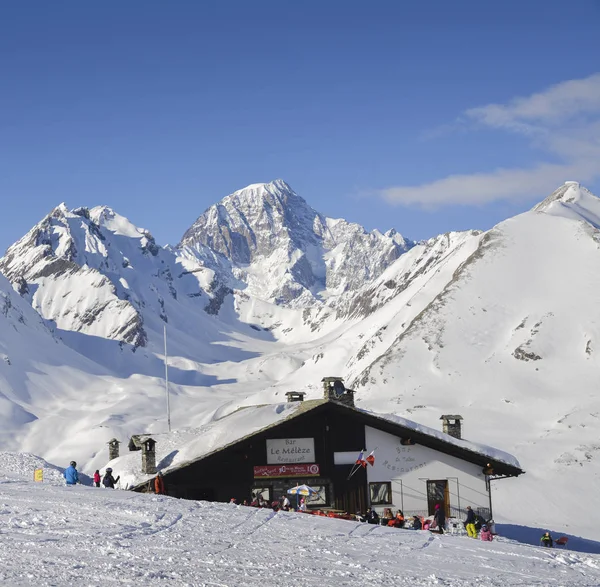 Skiers and snowboarders next to a wooden cabin in the Italian Alps during the winter, with copy space — Stock Photo, Image
