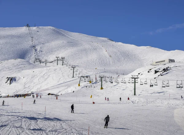 Elevador de cadeiras na área de esqui italiana em Alpes cobertos de neve e esquiadores e snowboarders na pista conceito de esportes de inverno — Fotografia de Stock