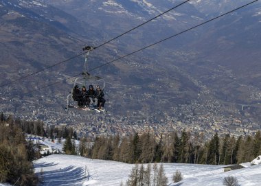 Dört orta yaşlı erkekler kayakçı Pila Kayak Merkezi Aosta Vadisi, İtalya dağ bir sandalye Asansör kaplar. Şehir Aosta arka planda
