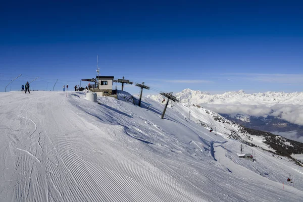 Chairlift at Italian ski area of Pila on snow covered Alps and pine trees during the winter with Mt. Blanc in France visible in background - winter sports concept — Stock Photo, Image