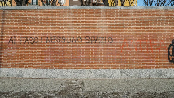 Graffiti op een rode bakstenen muur in het Italiaans zeggen al fasci nessuno spazio, vertaald naar geen ruimte voor fascisten - antifa thema — Stockfoto