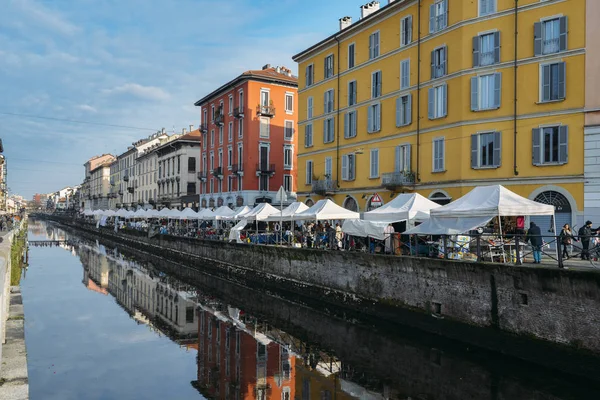 Flea market along the Naviglio Grande canal in bohemian Navigli district of Milan, Italy. The canal is 50km long — Stock Photo, Image