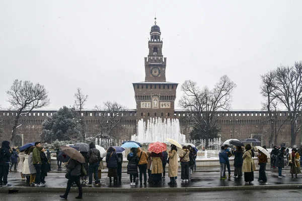 Ungewöhnlich kaltes und schneereiches Wetter aufgrund eines Phänomens namens Bestie aus dem Osten trifft Mailand, Lombardei, Italien. Asiatische Touristen vor dem castello sforzesco — Stockfoto