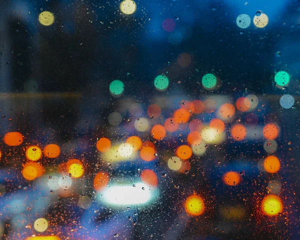 Fundo abstrato melancólico emocional com luzes desfocadas bokeh em Londres, Reino Unido atrás de gotas de chuva em vidro de janela, Concentre-se em algumas gotas devido à profundidade rasa do campo — Fotografia de Stock