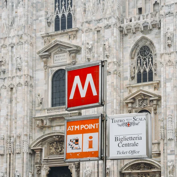 โกธิคหน้าของโบสถ์มิลานใน Piazza del Duomo พร้อมโคมไฟและป้ายรถไฟใต้ดินและทางเข้าสาย M1 — ภาพถ่ายสต็อก