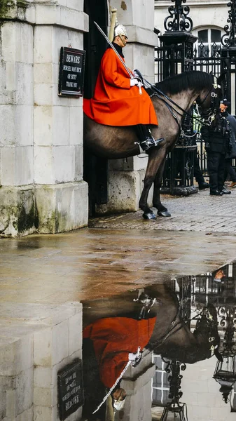 Mounted British guard on horse at Horse Guards parade ground on Whitehall, reflection on puddle - London tourist attraction — Stock Photo, Image