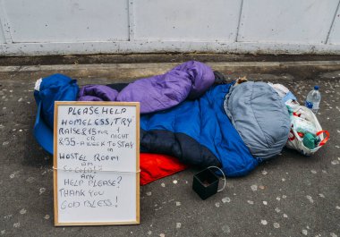 Uyku tulumu, gıda ve Kupası için Londra, İngiltere'de yakalanan Değiştir - kemer sıkma kavramı, evsiz biri kaldırım tarafındaki oturum