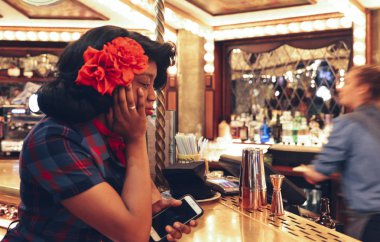 Genç afro 1950'lerde giymiş kadın barda, karşı bir düzeltmek karnaval Fuarı tarzı bar, uçuş yavrusu, Bloomsbury, Londra vintage sosyal dijital dartsclub Emlak