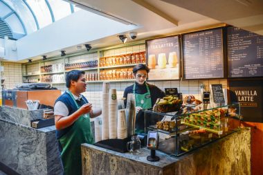 High Street Kensington, Londra, İngiltere ile dam penceresi bazı doğal ışık bir Starbucks kahve evinde iki Güneydoğu Asya baristas
