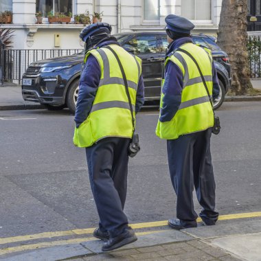 Two Highways Agency Traffic Officers, their purpose is to write tickets parking violations on Kensington and Chelsea, London streets clipart