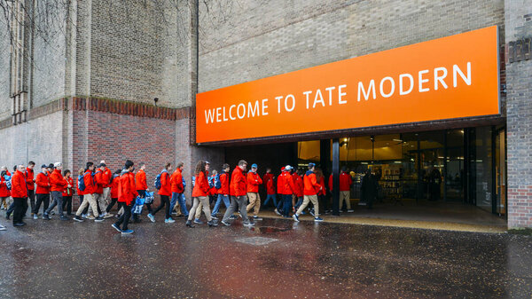 Школьная группа в форме входит в Тейт Модерн, музей современного искусства на Южном берегу Лондона
