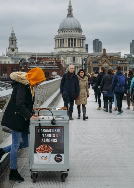 Young Cameralised peanut female seller at Londons Millennium Bridge overlooking St. Pauls Cathedral — Stock Photo, Image