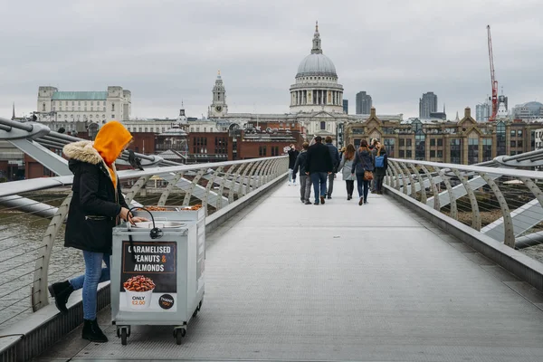 Mladá Cameralised arašídové ženské prodávajícího na londýnské Millennium Bridge s výhledem na St. Pauls Cathedral — Stock fotografie