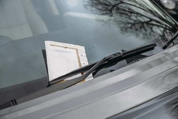 Bilhete de estacionamento preso no pára-brisas do carro por uma penalidade ou multa . — Fotografia de Stock