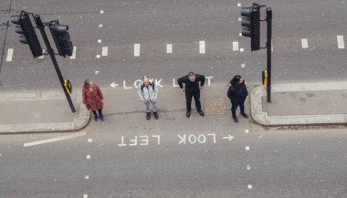 Londra şehir yayalar karşıdan karşıya geçerken yüksek perspektif görünümü. İkonik göz sol ve sağ işaret turist trafik yönünü, yardımcı olmak için boyalı bak