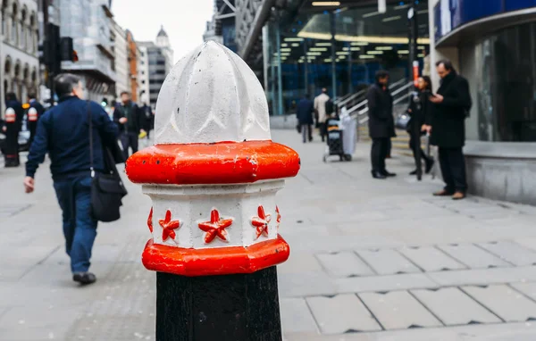 Selective focus on a bollard in the City of London, with City workers in the background — Stock Photo, Image