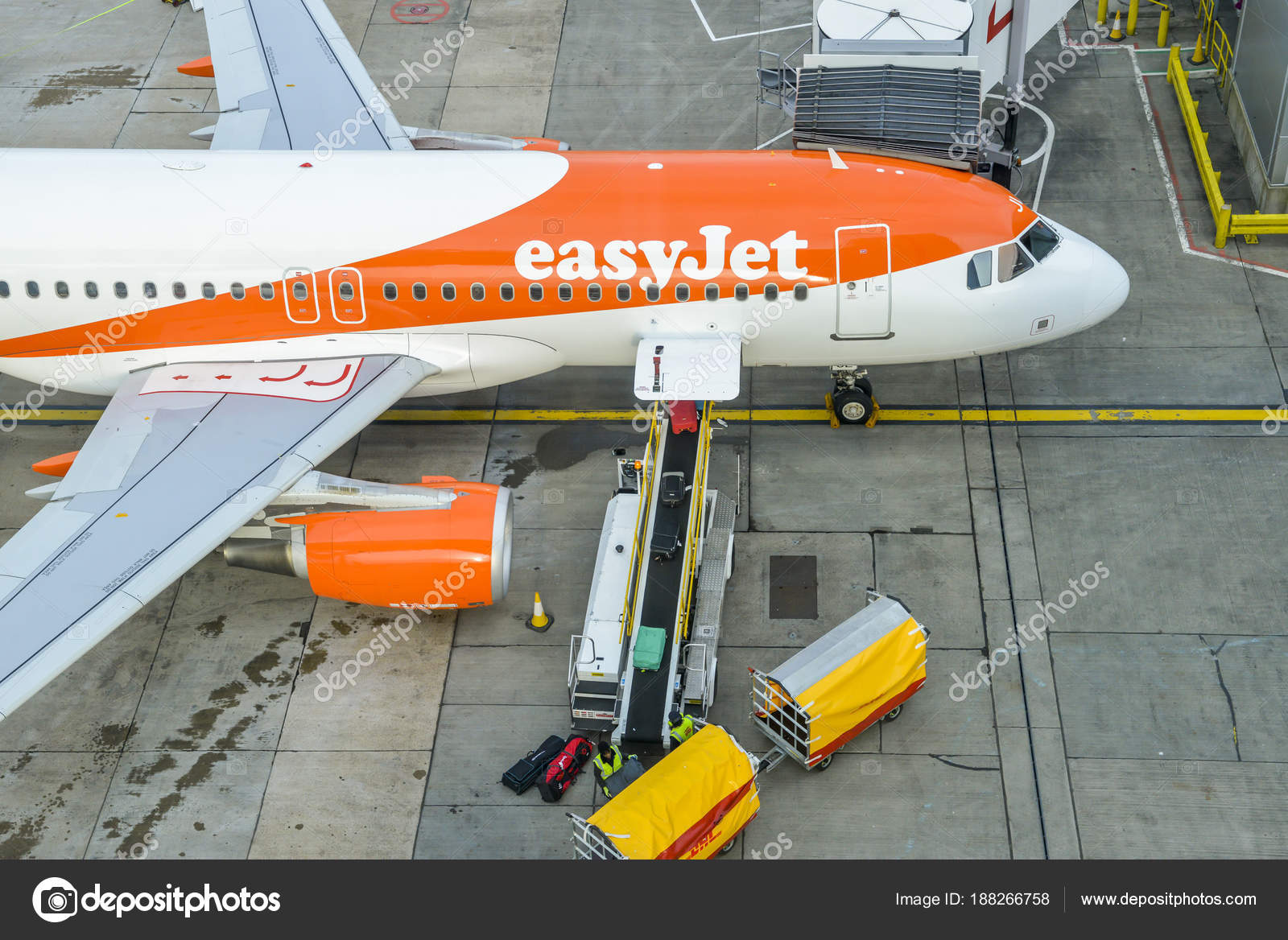 High perspective of baggage handlers picking up suitcases from a
