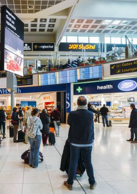 Yolcu Londra Gatwick'ın Kuzey Terminal bir dijital ekranda uçuş bilgilerini denetleyin. Alışveriş yapmak ve yolcu beklerken yemek çeşitli seçenekleri