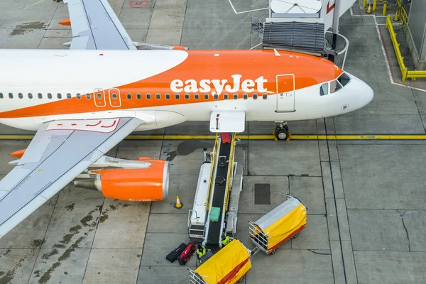 Londra Gatwick'ın Kuzey terminalde Airbus A320 easyjet uçak Bagaj işleyicileri bir Konveyör bant üzerinden bavul toplayıp yüksek bakış bağlı