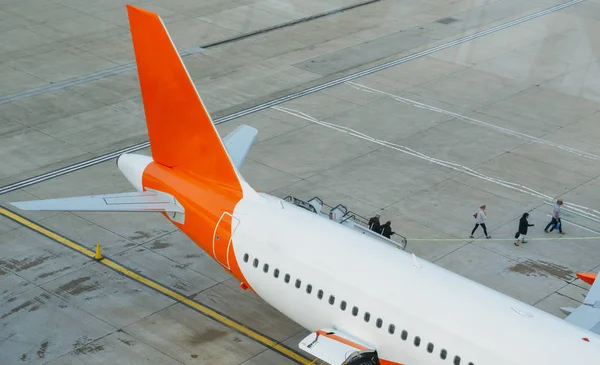 Les passagers débarquent d'un avion et marchent sur l'aire de trafic vers le terminal . — Photo