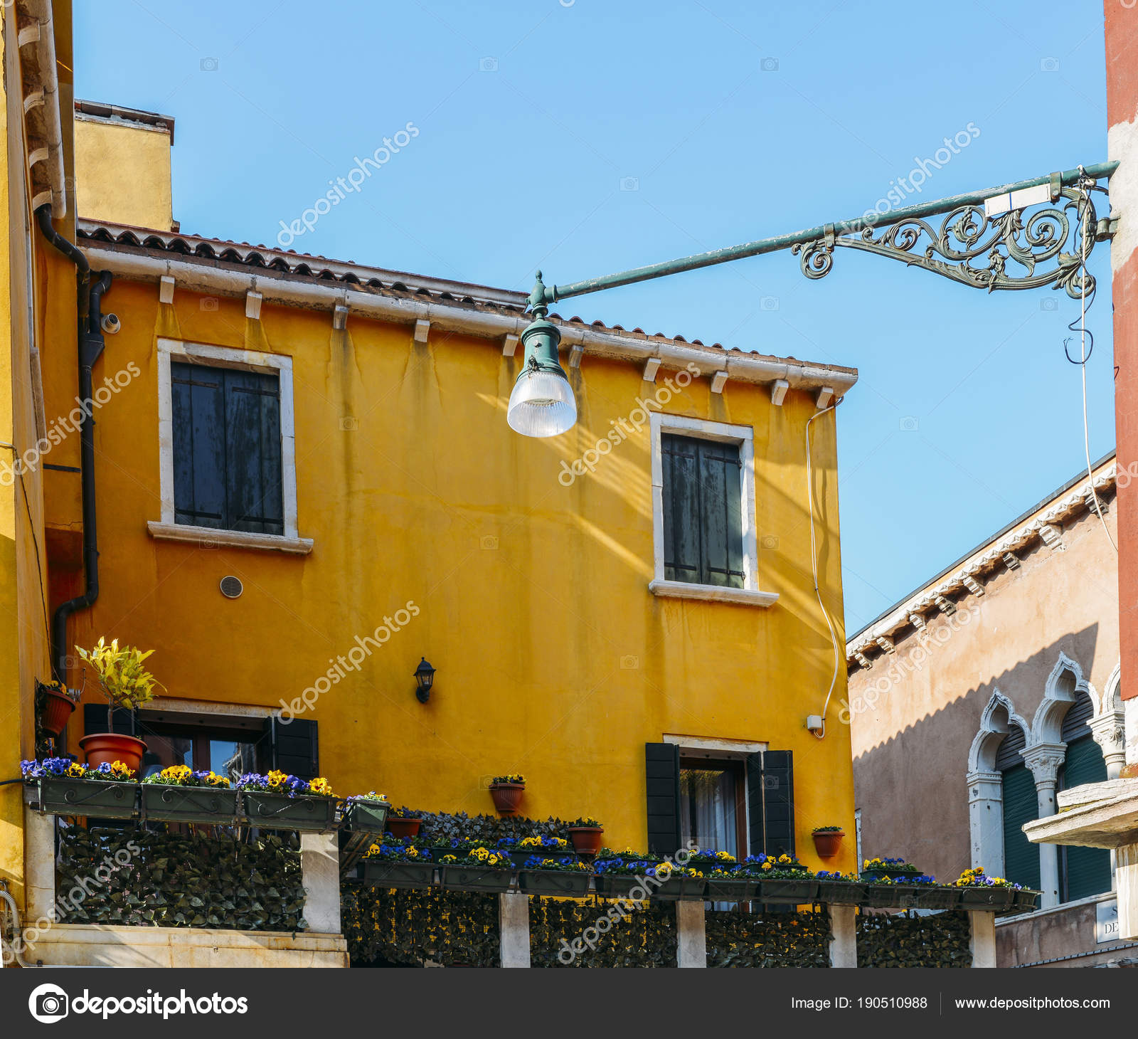 Yellow house with flowers and bench Colorful houses in Burano