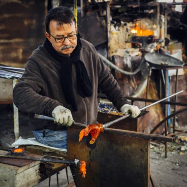 Cam üfleyici güzel bir cam parçası oluşturuyor, Murano, Venedik, İtalya