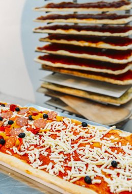 Pişmemiş dikdörtgen Roma tarzı pizza salam tepesi ile