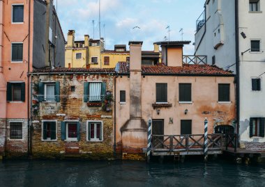 Cephe kısmen yosunlu eski tuğla House ile ahşap vintage kapı dar kanal Venedik, İtalya