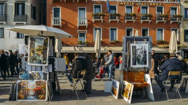 Bilinmeyen sanatçı resimleri Venedik sahildeki satıyor. Tüm dünyadan gelen turistler İtalya, ünlü Unesco Dünya Mirası tarihi şehir Venezia tadını çıkarın.