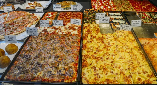 Pizz, z opisami włoski, na sprzedaż na sklep okno przednie w Wenecji w różnych smakach. — Zdjęcie stockowe