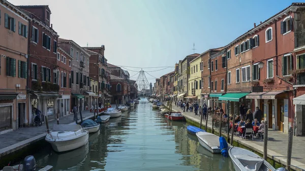 Visa turister intill en kanal med båtar på ön Murano — Stockfoto