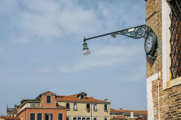 Clock and lantern hanging on a corner the house in Venice, Italy. — Stock Photo, Image