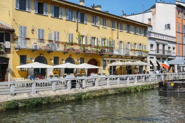 People relax at a restaurant terrace in the popular Navigli district of Milan — Stock Photo, Image