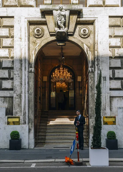 A security man stands on the doorway to a luxurious gothic entrance to a building — Stock Photo, Image