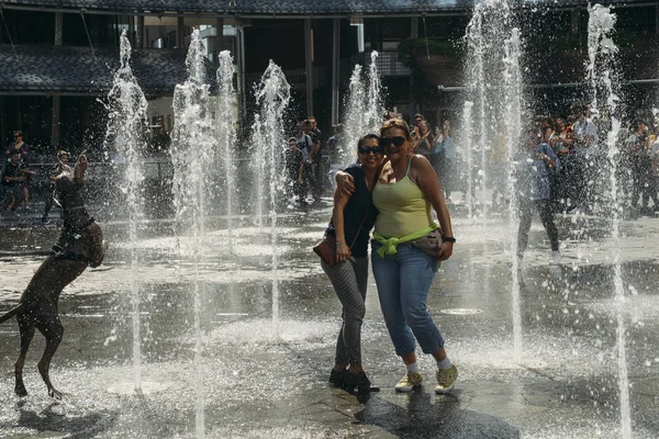 Milan, Italia - 25 April 2018: Orang-orang mandi di air mancur di Aulenti Square, dikelilingi oleh pencakar langit modern, di distrik bisnis Porta Nuova — Stok Foto